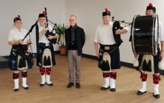 Photo M. David Kerr avec des joueurs de cornemuse